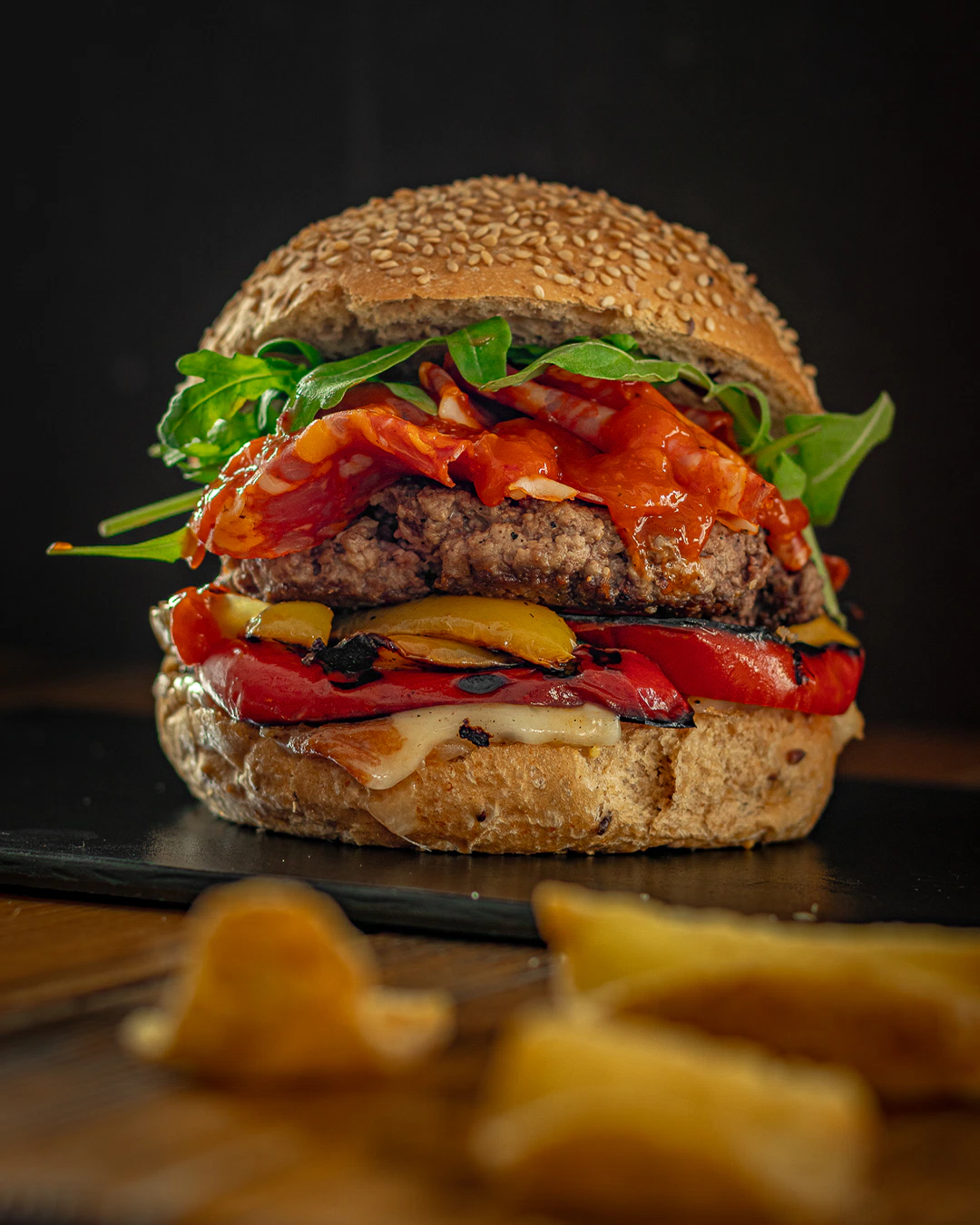 Pane Antichi Cereali, Hamburger di Fassona piemontese Coalvi, Rucola, Taleggio DOP, Spianata piccante, Peperoni grigliati e Salsa Relish